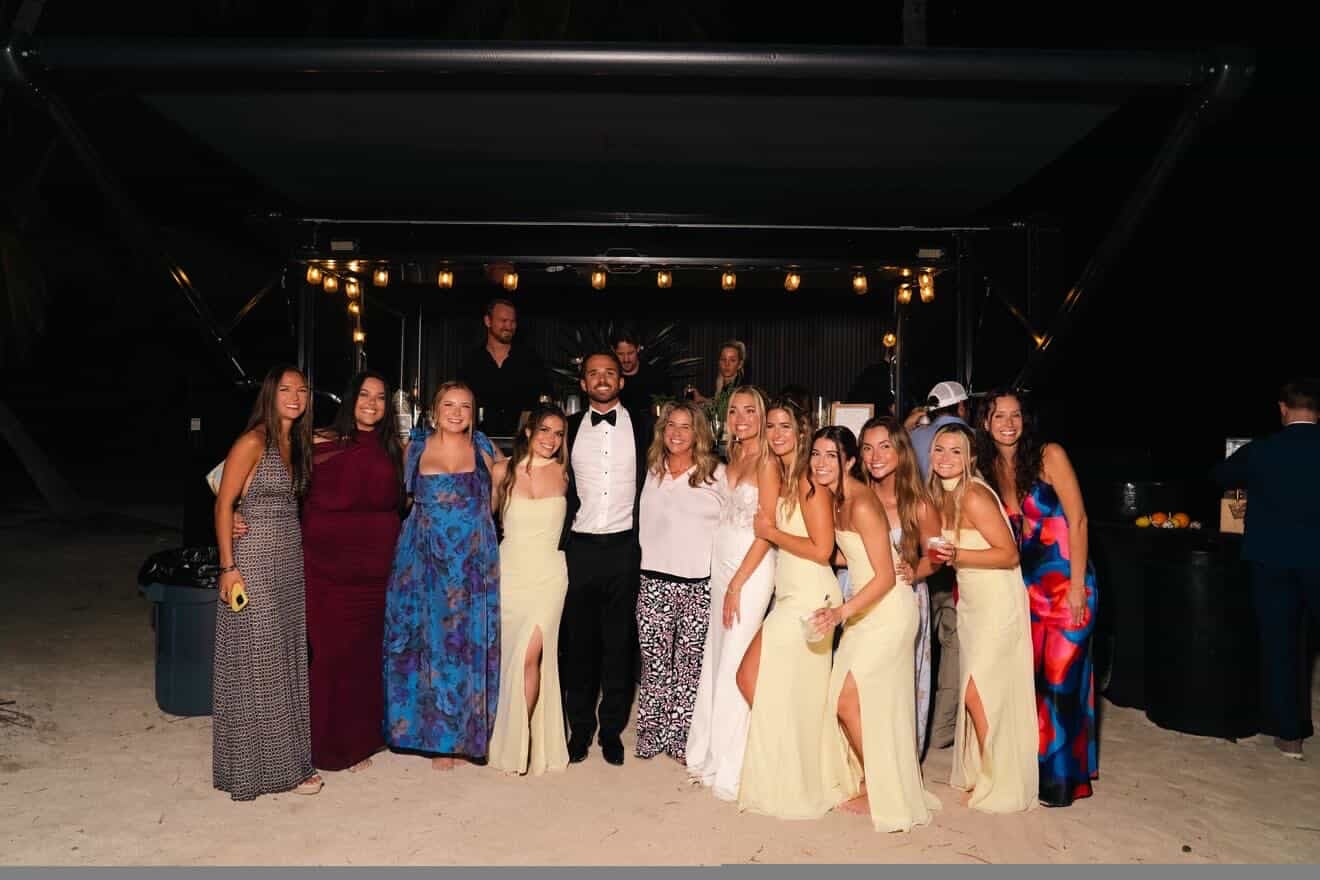 Group of people posing together at an event with a dark background