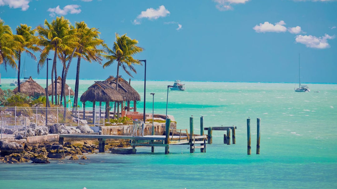 Florida Keys' Dock with palm trees and boats on clear blue water