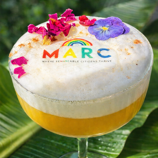 Cocktail in a glass with whipped cream, flowers, and &