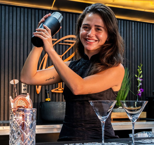 Woman in a mobile bar holding a cocktail shaker with a modern interior background