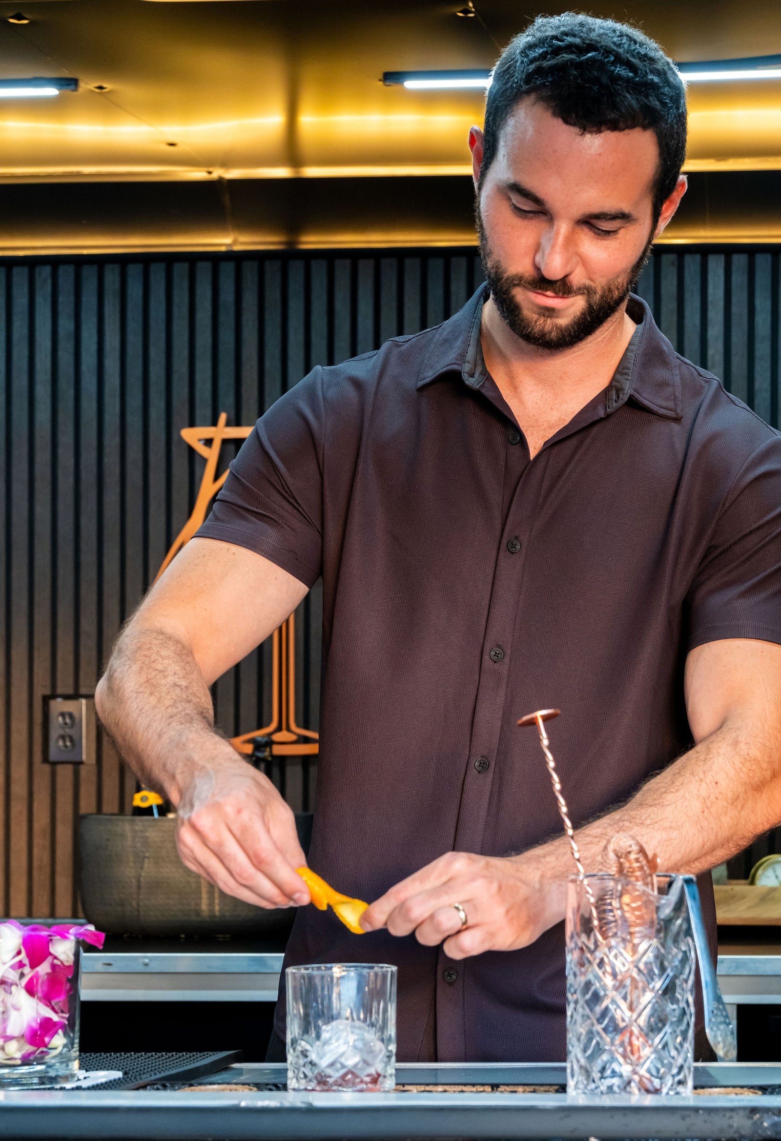 Bartender preparing a drink at a bar with a modern interior.