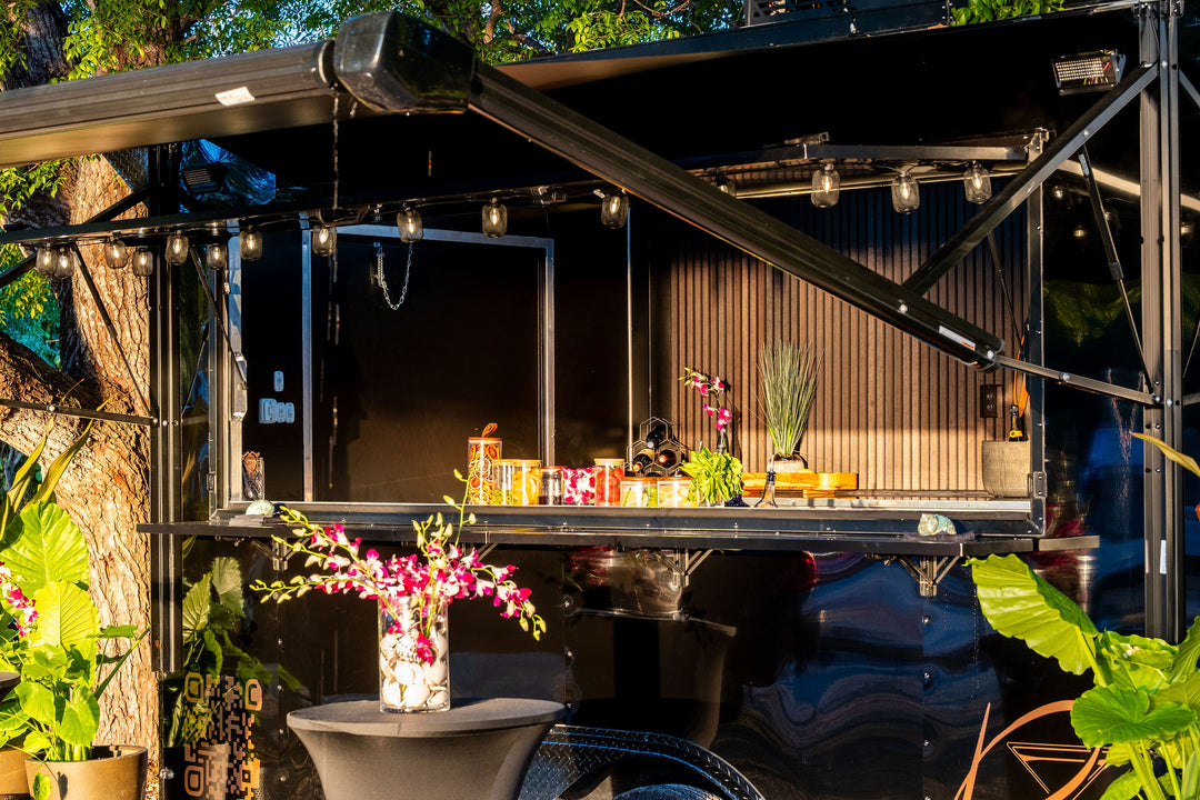 Mobile Bar Trailer with drinks, garnishes, and decorative plants.
