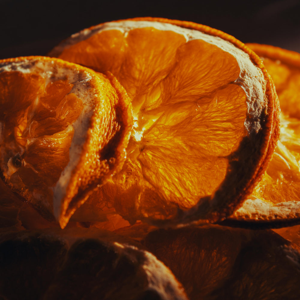 Dehydrated orange slices with a warm, brownish-orange color on a dark background
