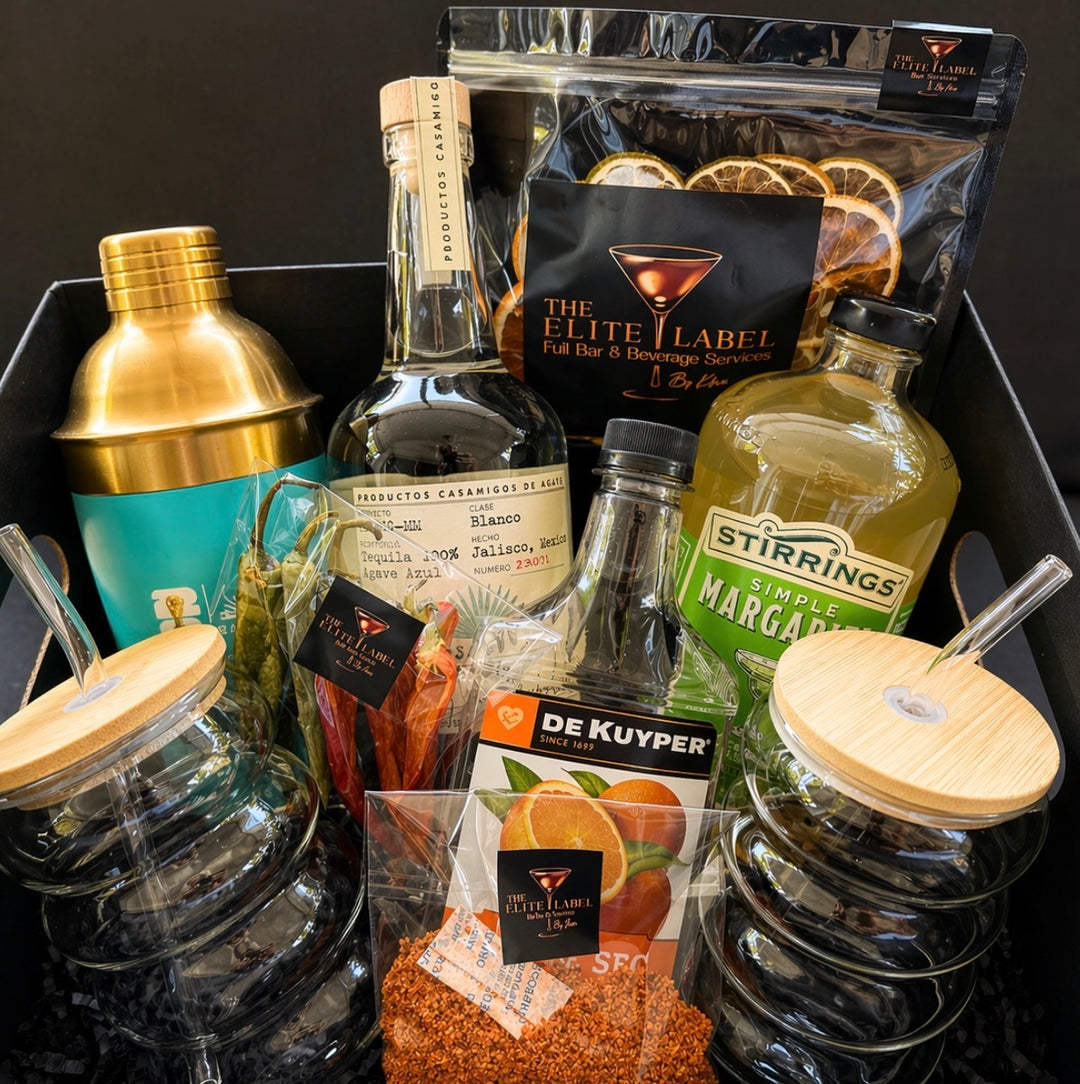 Alcohol bottles, mixers, and bar tools in a gift basket with 'The Elite Label' branding.