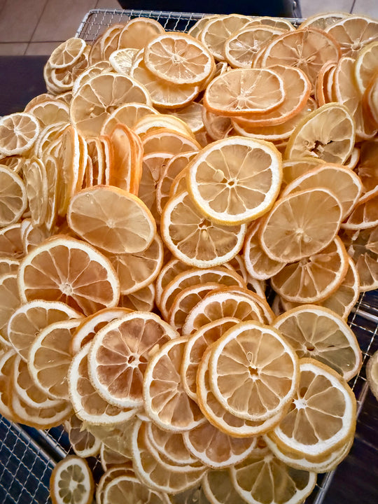 Stack of dehydrated orange wheels on a metal rack.