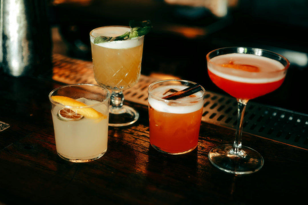 Five cocktails on a pop up bar counter with garnishes