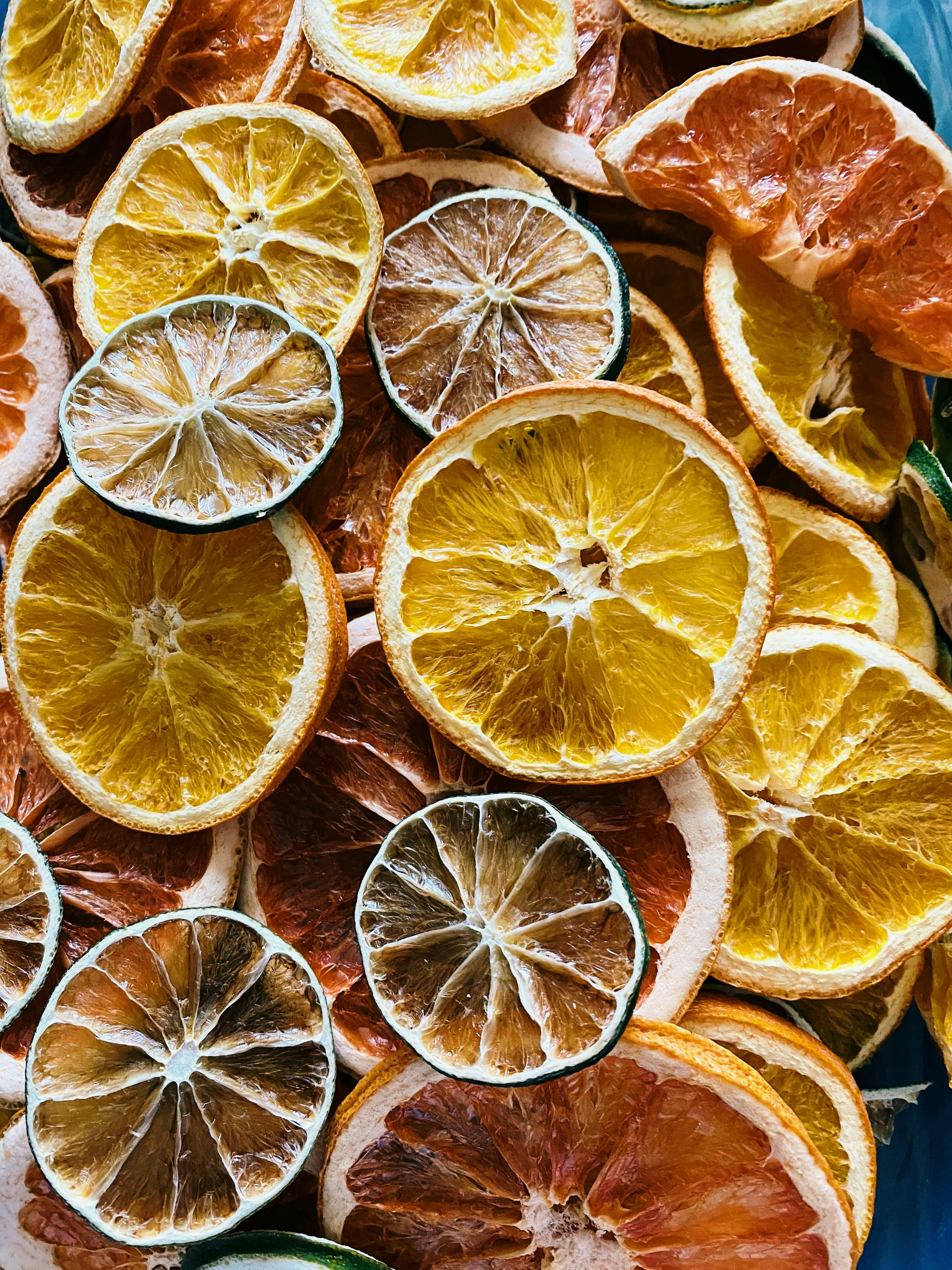 Stack of dehydrated citrus slices including oranges, lemons, and limes.