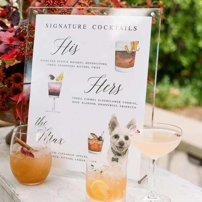 Table with cocktails and a 'Signature Cocktails' menu card featuring a dog illustration.